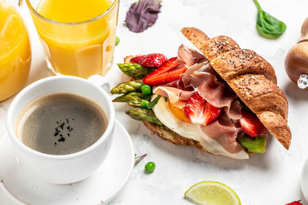 American breakfast sandwiches Croissant with avocado, asparagus, jamon, ham, prosciutto,...