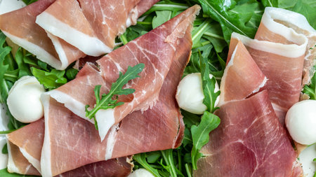 Antipasto salad with prosciutto, mozzarella cheese and arugula, Antipasti, a traditional Italian, Food recipe background. close up.の写真素材