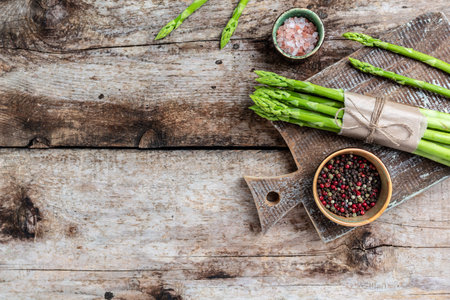 Bunches of green asparagus on rustic wooden table. banner, menu recipe place for text, top view.の写真素材
