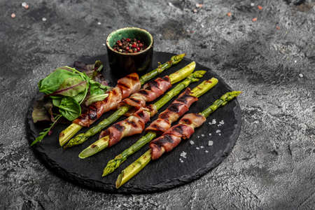 Grilled green asparagus wrapped with bacon. The ketogenic diet. Healthy food, diet menu. top view, overhead, bannerの写真素材