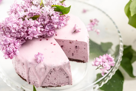 velvet mousse cake with blueberries decorated with a bouquet of purple blooming lilac, French...