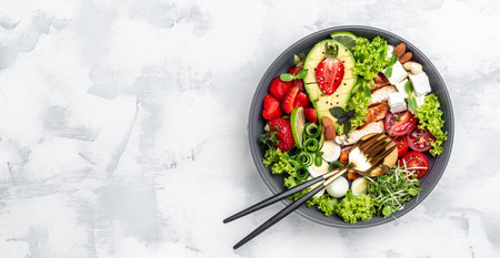 Grilled chicken, avocado, feta cheese, quail eggs, strawberries, nuts and lettuce on white background, top view. Delicious balanced food concept. Long banner format. top view.の写真素材