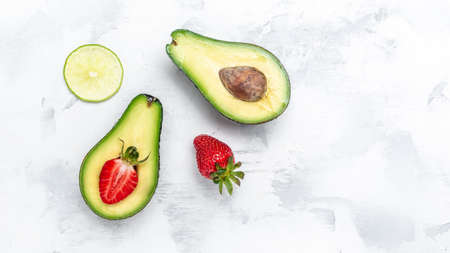Avocado cut half and slice with strawberry on white background. clean eating for weight loss....