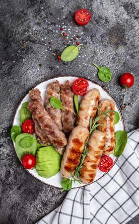 Grilled Munich Veal Sausages and meat rolls wrapped bacon, chevapchichi or Kofta kebab. Ketogenic diet, vertical image. top view. place for text.の写真素材