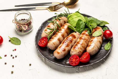 Homemade Pork Sausages with spinach, avocado and cherry tomato. Keto paleo diet menu. top view.の写真素材