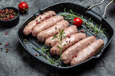 raw sausages with spices and rosemary. Food recipe background. close up.の写真素材