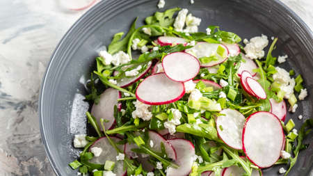 Spring salad with radishes, arugula and cottage cheese on dark background, Restaurant menu, dieting, cookbook recipe.の写真素材