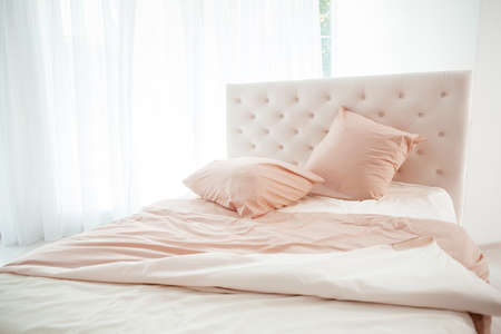 Cozy bedroom interior, Large bed by the window in pastel colors,の写真素材