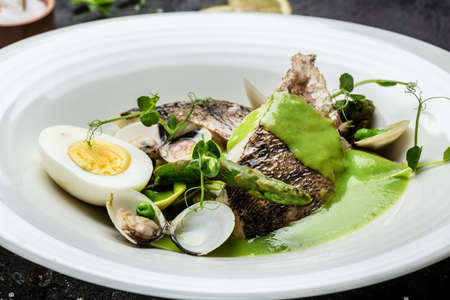 Fish dish - fried fish fillet of zander served with mussels, peas, asparagus and vegetable cream...