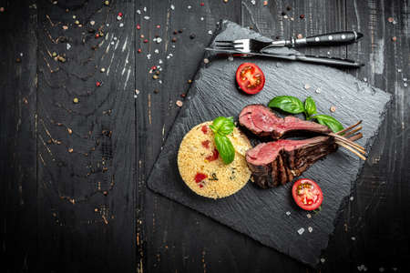 Roasted Rectangle Rack of Lamb Chops with couscous. on wooden background. banner, menu, recipe place...