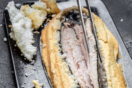 Fish covered in meringue salt. Tray with fish and lemon. Breaded river trout fish. New delicious fish recipe. still life. top view. Health food.の写真素材