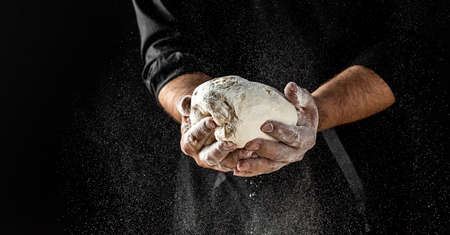 Male hands making dough for pizza. Beautiful and strong men's hands knead the dough make bread, pasta or pizza.の写真素材