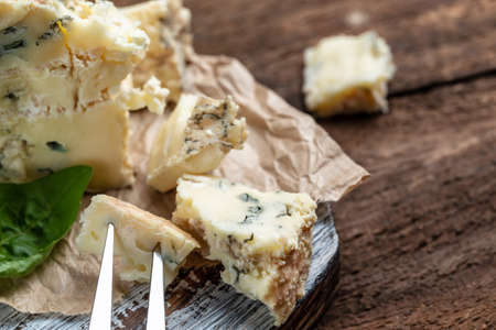 French cheeses blue cheese dorblu, gorgonzola, roquefort on wooden table.