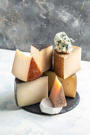 Cheeseboard. Different sorts of cheese. traditional pieces of Spanish, French, Italy cheese. vertical image. top view. place for text.の写真素材