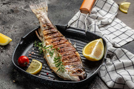 Baked trout fish on the grill pan with lemon. Delicious balanced food concept. top view.