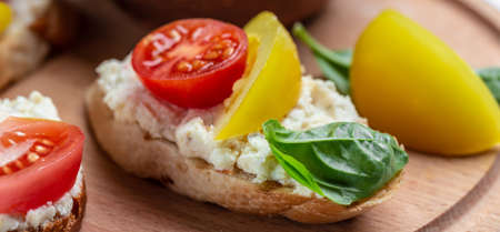 Open sandwich tomato, soft cheese, basil. Delicious breakfast or snack, Clean eating, dieting, vegan food concept. top view.の写真素材