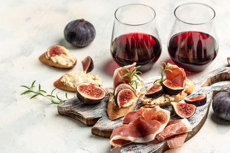 Crostini with prosciutto, cream cheese, figs. traditional spanish tapas set antipasti with red wine. banner, menu recipe. top view.の写真素材