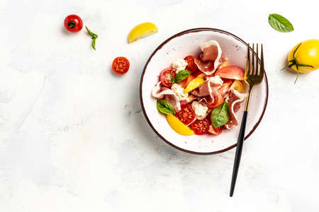 Salad with Prosciutto, ham jamon, tomatoes, cheese. cold snacks. Food recipe background. close up view.の写真素材