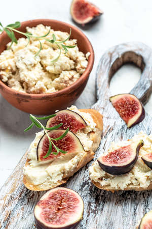 Fresh figs, cream cheese bruschetta on wooden table, Italian Bruschetta Menu, recipe, top view,の写真素材