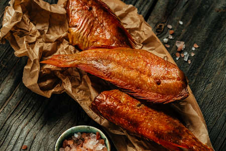 homemade smoked river bass fish on wooden cutting board. Food recipe background. close up,