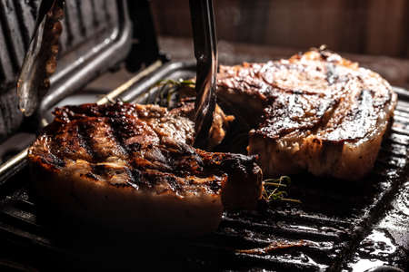 Grilled pork chop on grill with delicious toasted traces and fragrant smoke. organic food. top view.の写真素材