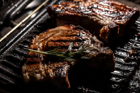 pan with grilled steak. Grilled pork chop on grill with delicious toasted traces and fragrant smoke.