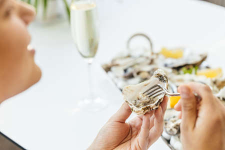oyster. man eating shellfish. Seafood and Mediterranean cuisine with mussels in shell. oyster in...