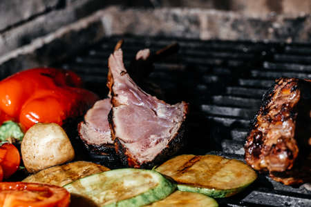 Meat lamb on the grill. Lamb ribs on board with grilled vegetables. Restaurant menu, Culinary,...