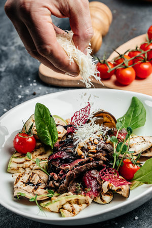Beef steak barbecue sliced with salad grilled vegetables, nuts, sauce and parmesan. Italian food concept.の写真素材