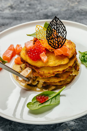 Crispy potato pancakes with red caviar, red fish and mushroom sauce. Stack of potato pancakes fried. vertical image. top view. place for text.の写真素材