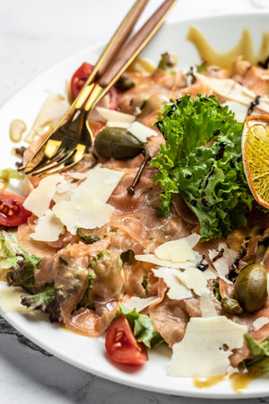 salmon carpaccio with parmesan cheese, capers, parmesan and cherry tomatoes. Food recipe background. Close up, top view.の写真素材