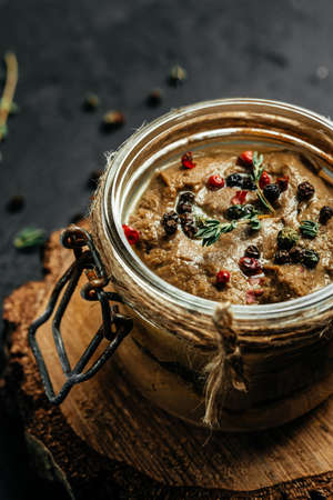 glass jar of liver pate or mousse. homemade chicken liver pate in a glass jar, vertical image. top...