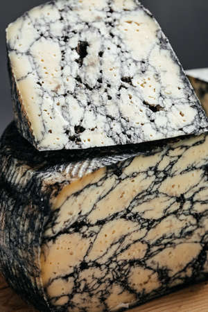 Asiago hard cheese with cuttlefish ink. delicious dairy products. Food recipe background. close up.の写真素材
