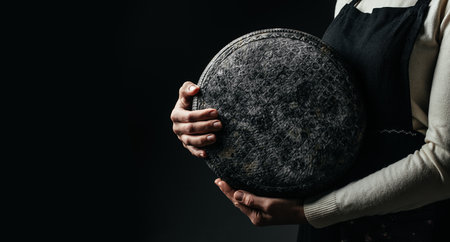 A cheesemaker controls the seasoning of the wheel hard cheese, delicious dairy product. Long banner format.の写真素材