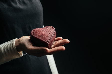 woman holding red Heart shaped hard cheese on a dark background. valentines day concept,の写真素材