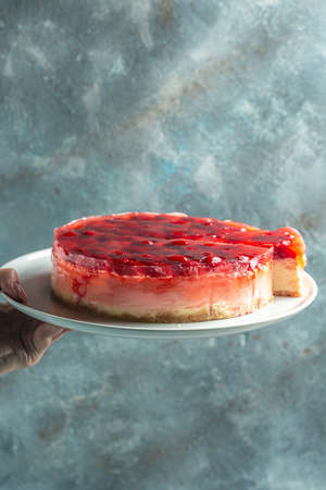 strawberry cheesecake with berries jelly, jam on blue background.