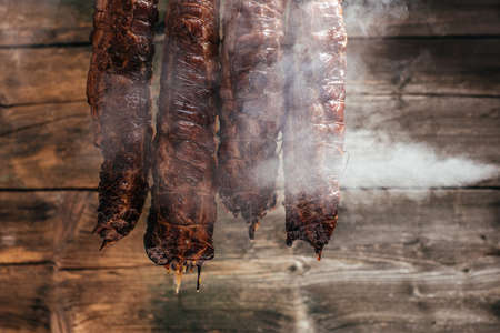 Ham smoked with smoke cold on dark background. banner, menu, recipe place for text.の写真素材