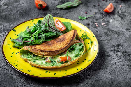 Breakfast Frittata made of eggs, cheese and spinach salad on a yellow plate on a gray background. Ketogenic, keto food. banner, menu recipe top view.の写真素材