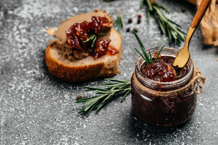 Red onion marmalade jam confiture in jar. Vegetable jam on dark background. Delicious sauce. french cuisine. Food recipe background. space for text.の写真素材