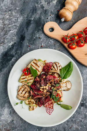 barbecue steak sliced with salad grilled vegetables, nuts, sauce and parmesan. Italian food concept. banner, menu, recipe place for text, top view.の写真素材