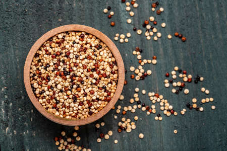 Sets quinoa seeds on a wooden bowl. Healthy and diet superfood product. Long banner format, top view.の写真素材