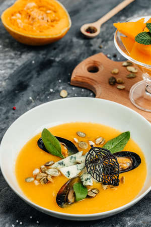 pumpkin cream soup with mussels, blue cheese, mold. Delicious balanced food concept. top view.の写真素材