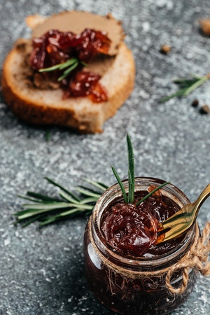 Red onion marmalade jam confiture in jar. Vegetable jam on dark background. Delicious sauce. french cuisine. Food recipe background. space for text.の写真素材