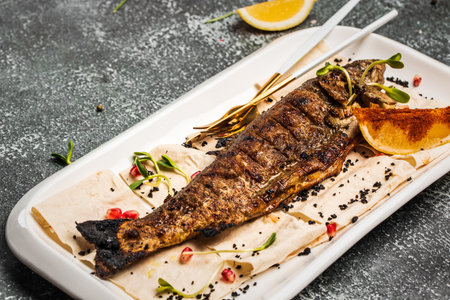 Baked trout fish with salt, lemon. Grilled trout. Fish dish fried fish fillet with vegetables. Ketogenic, keto or paleo diet lunch, Healthy food trend. top view.の写真素材