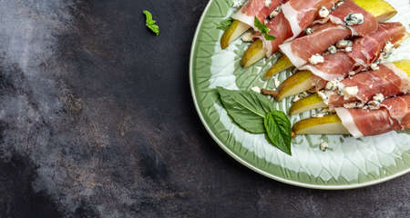 Appetizer with pear, blue cheese and prosciutto ham, Healthy fats, clean eating for weight loss, Long banner format. top view,の写真素材