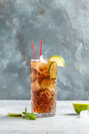 Cuba Libre or long island iced tea cocktail with strong drinks, cola, lime and ice in glass, Alcoholic or non-alcoholic cold longdrink or lemonade,の写真素材