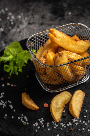 Baked potato wedges with herbs, homemade organic vegetable vegan vegetarian potato wedges snack,...