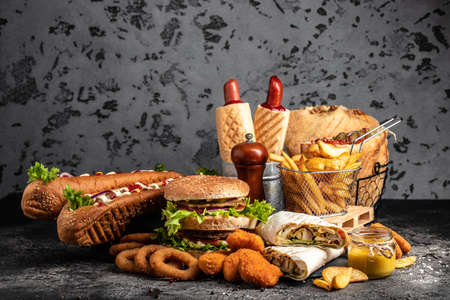 Variety of fast food, home made tasty burger and hot dogs with fried chicken french fries. traditional American food. fast food.の写真素材