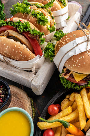 Hamburgers and French fries on the wooden tray. Traditional American fast food. vertical image. top view.