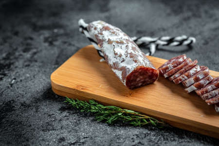 Fuet Salami cut in slices. Traditional Spanish sausage on wooden board. Fuets Catalan dry sausages. top view.の写真素材